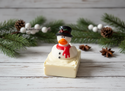 Snowman-shaped soap on a wooden surface with Christmas decorations